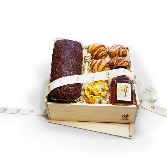 Rosh Hashanah Bakery and Honey Gift Box with honey cake, rugelach, honey, honey dipper, and candies in a wooden crate.