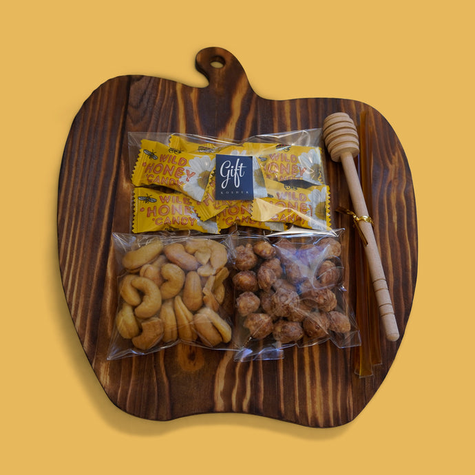 Rosh Hashanah honey gift with nuts, candy, and honey dipper on apple board – kosher holiday gift