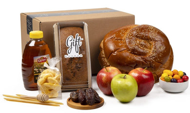 Rosh Hashanah in a Box by Gift Kosher includes hoey cake, bottle of honey, apples, honey sticks